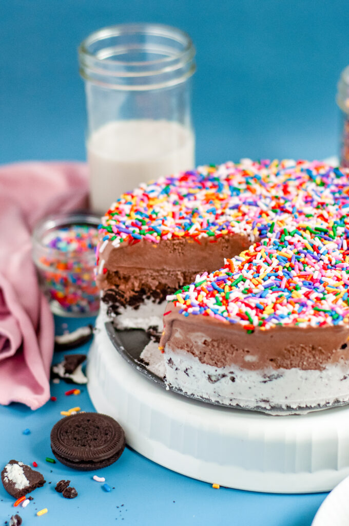 Ice Cream cake with and Oreo crust bottom covered in rainbow sprinkles.