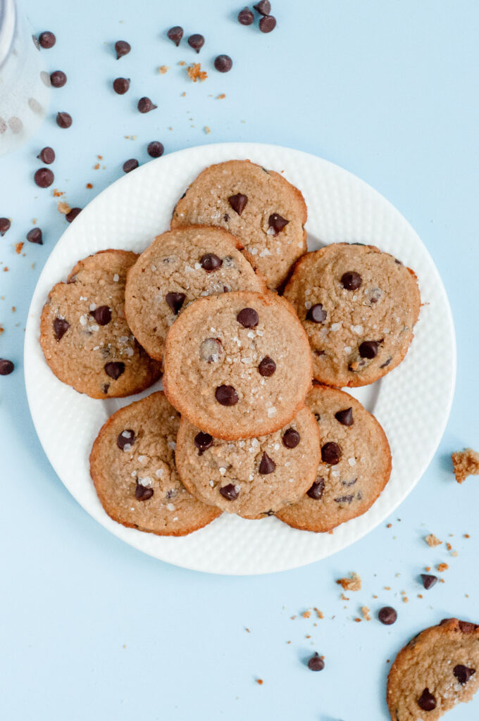 A stack of Low-Sugar Brown Butter Chocolate Chip Cookies with golden edges, melty chocolate chips, and a rich, nutty aroma.