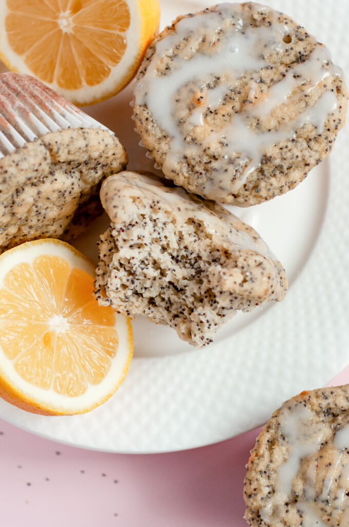 A batch of golden Lemony Sunshine Chia Muffins with a light, fluffy texture, speckled with chia seeds, and topped with a vibrant lemon glaze.