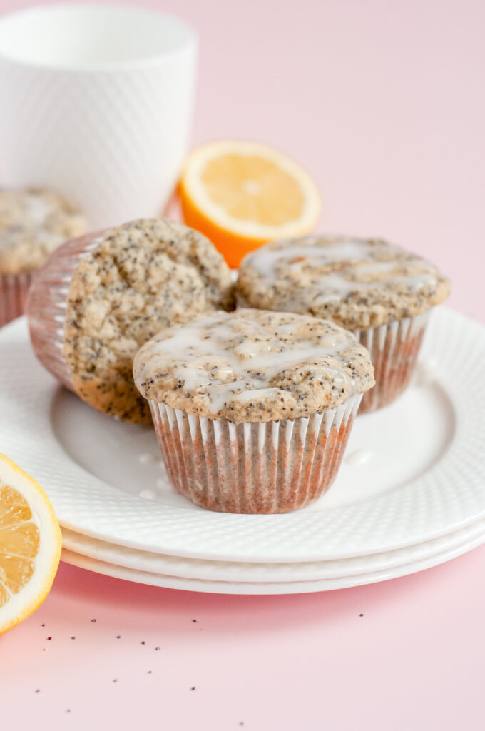 A batch of golden Lemony Sunshine Chia Muffins with a light, fluffy texture, speckled with chia seeds, and topped with a vibrant lemon glaze.