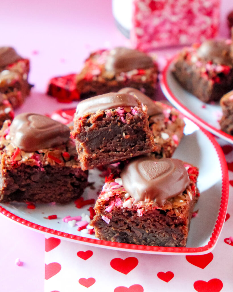 A stack of fudgy Berry Much in Love Brownies with a glossy berry swirl, rich chocolate layers, and a decadent, moist texture.