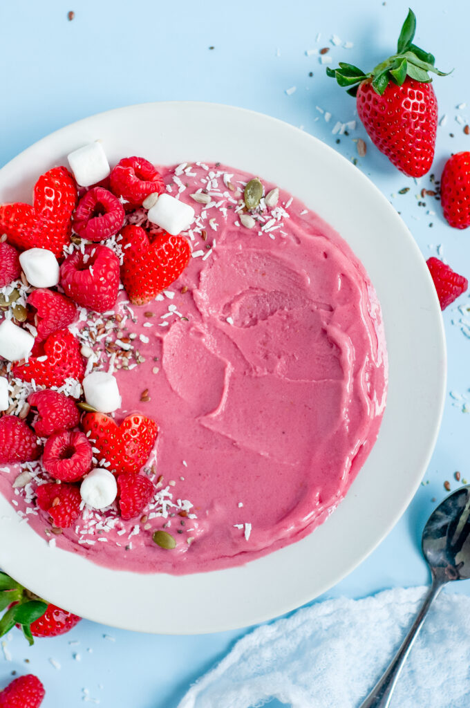 Strawberry Creami bowl with strawberry shaped strawberries and raspberries.