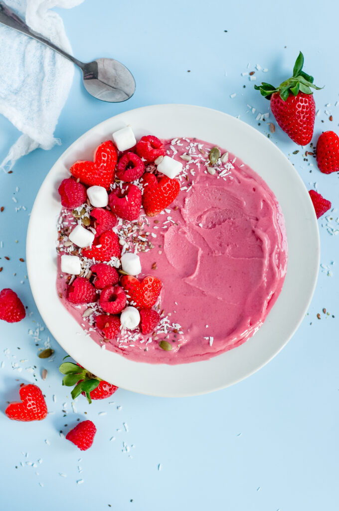 Close up of Strawberry Cream Bowl with strawberries, marshmallows, raspberries, and sprinkles.