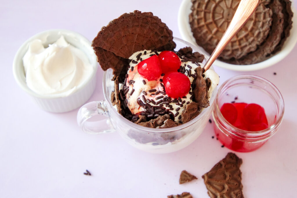 Pizelle ice cream sundae topped with chocolate sauce and sprinkles.