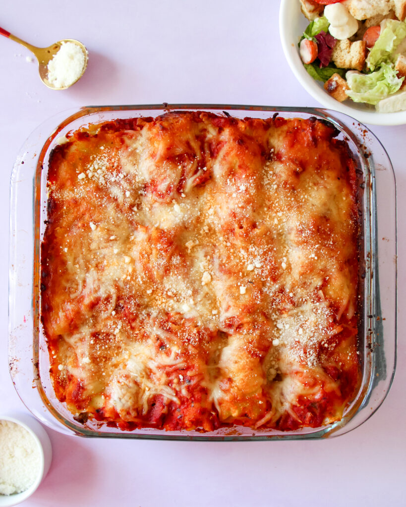 Cheesy baked lasagna rolls topped with marinara sauce and fresh basil