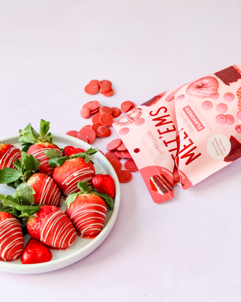 Red velvet chocolate-covered strawberries with a white chocolate drizzle, arranged on parchment paper – a vibrant, sweet treat perfect for any celebration.