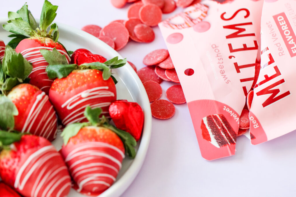 Red velvet chocolate-covered strawberries with a white chocolate drizzle, arranged on parchment paper – a vibrant, sweet treat perfect for any celebration.