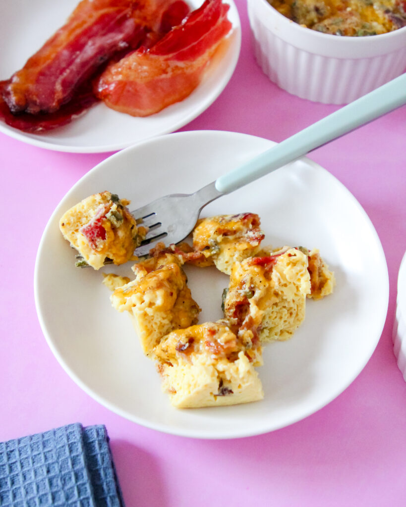 Mini egg and cheese soufflés baked in ramekins, golden and fluffy, served with fruit and bacon for a fun weekend breakfast.