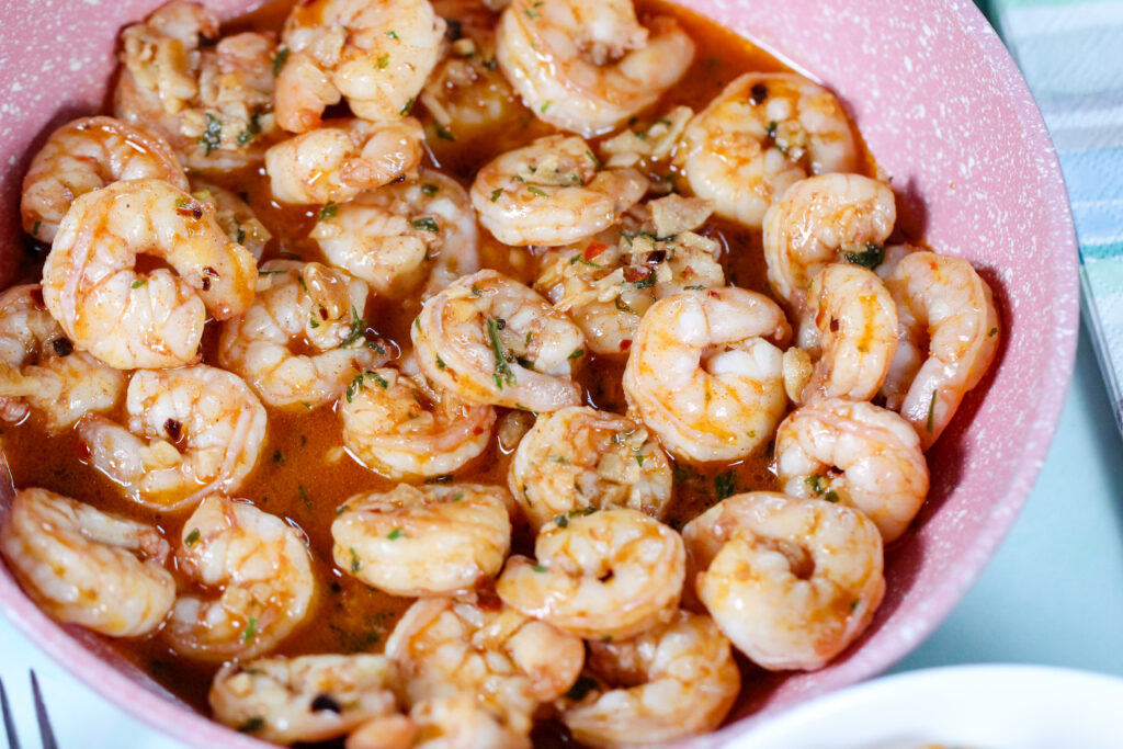 Garlic shrimp cooked in butter and topped with Hawaiian red sea salt, served in a skillet with fresh parsley.