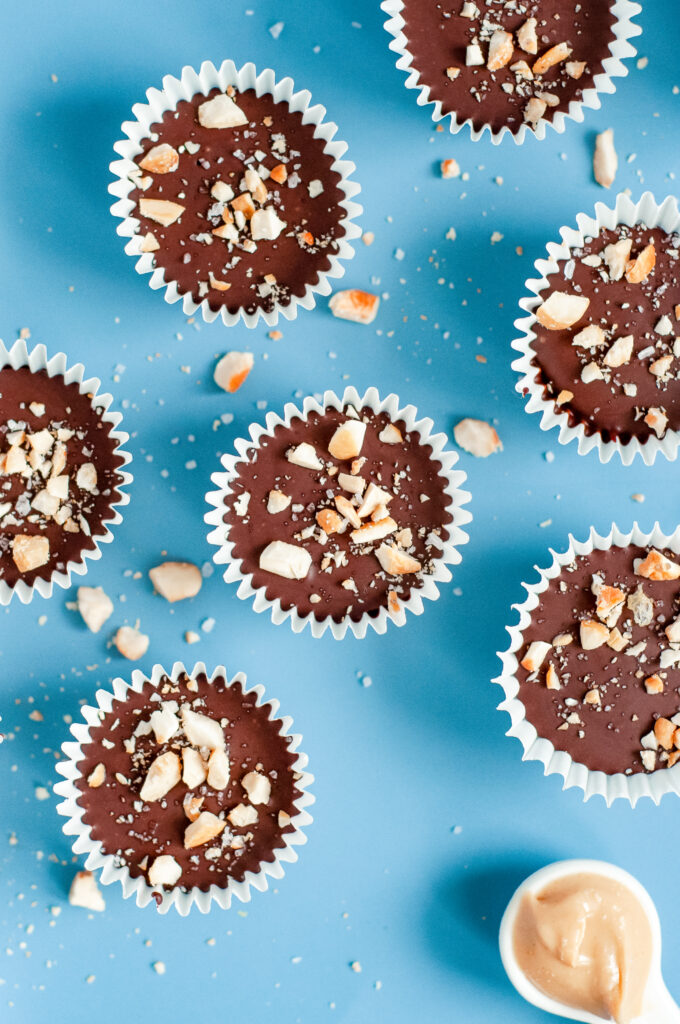 Homemade Better-For-You Chocolate Nut Cups in mini muffin liners, sprinkled with crushed nuts.