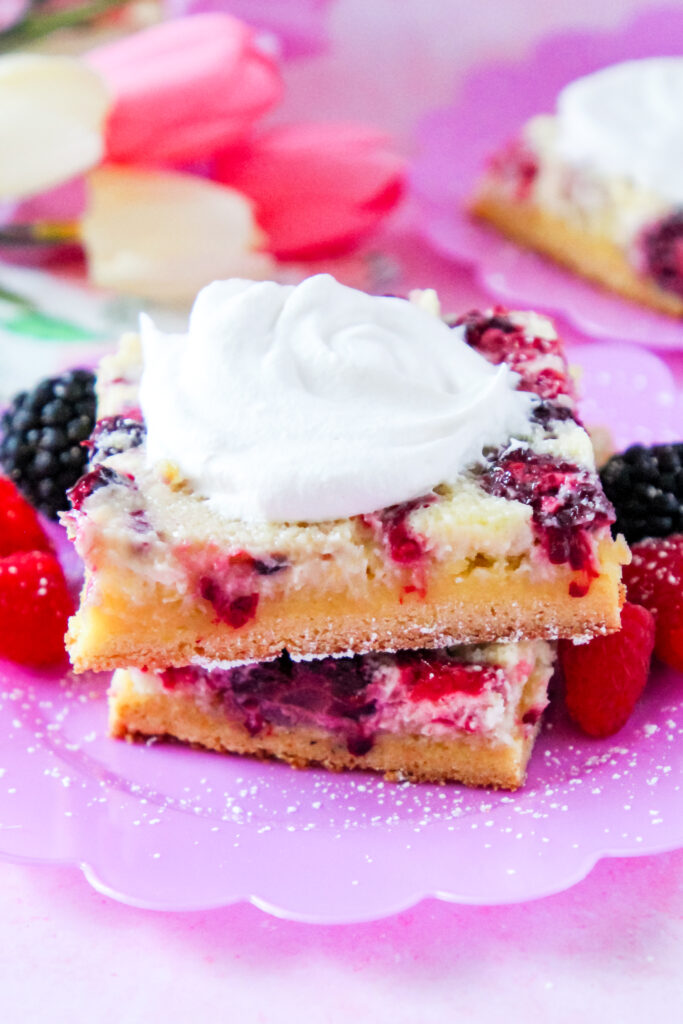 Close-up of a slice of Lemon Berry Gooey Butter Cake with a golden crust and creamy berry filling.