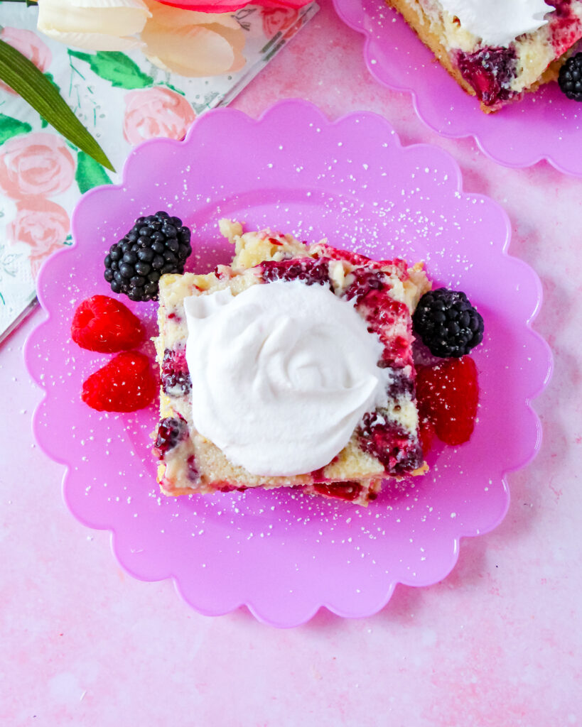 Close-up of a slice of Lemon Berry Gooey Butter Cake with a golden crust and creamy berry filling.