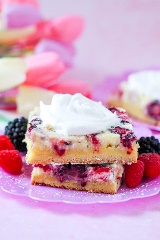 Close-up of a slice of Lemon Berry Gooey Butter Cake with a golden crust and creamy berry filling.