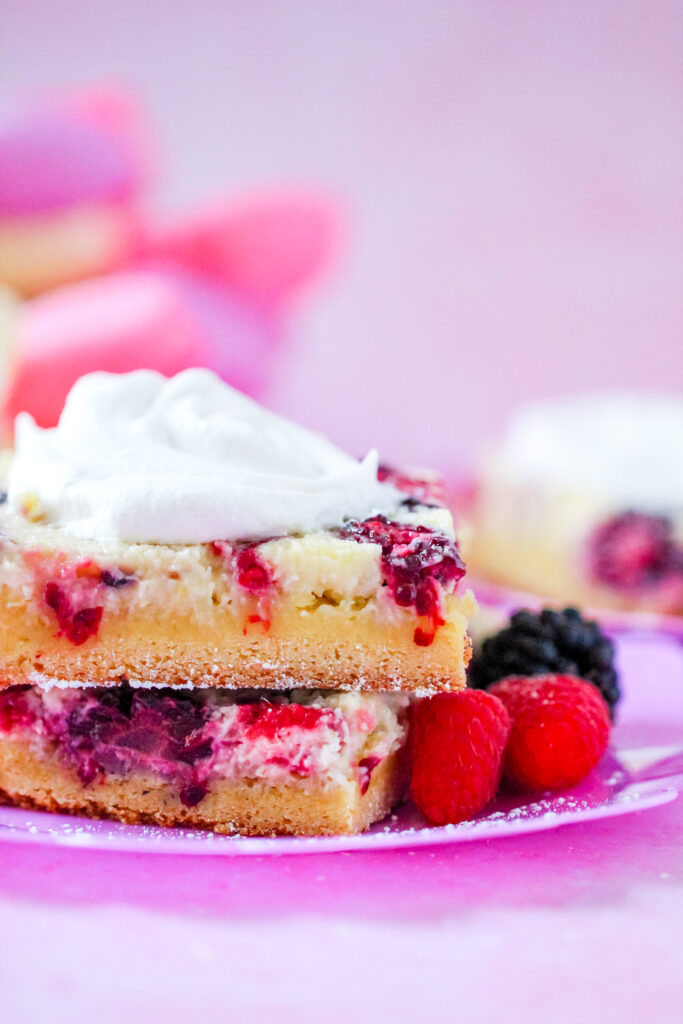 Close-up of a slice of Lemon Berry Gooey Butter Cake with a golden crust and creamy berry filling.