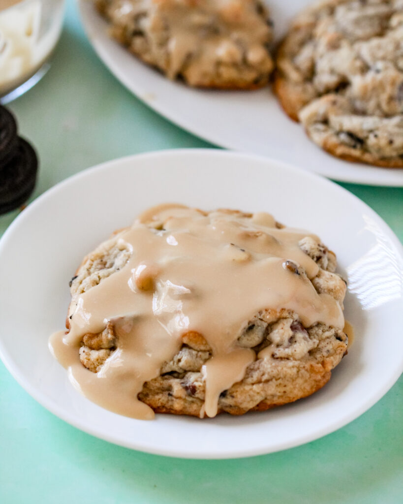 A close-up of thick, jumbo Baileys Irish Cream cookies with melty chocolate, toffee, and crushed chocolate sandwich cookies.