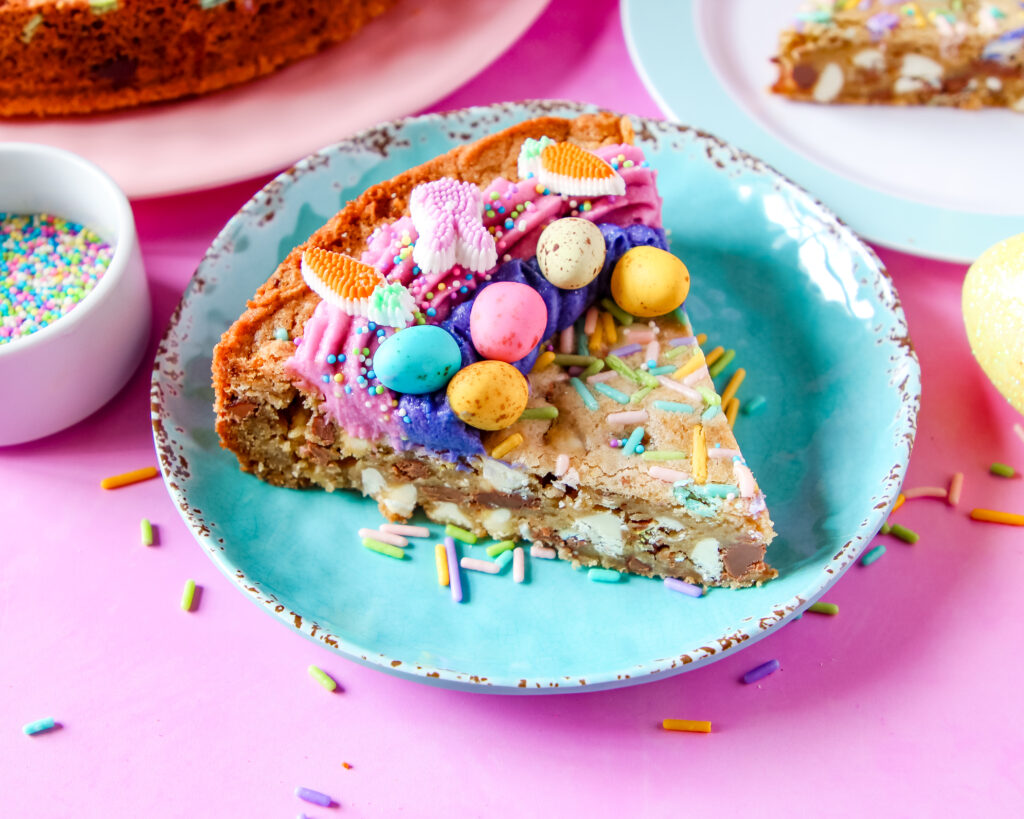 Egg-stravaganza Cookie Cake decorated with pastel swirls, nonpareils, and extra chocolate eggs on top.