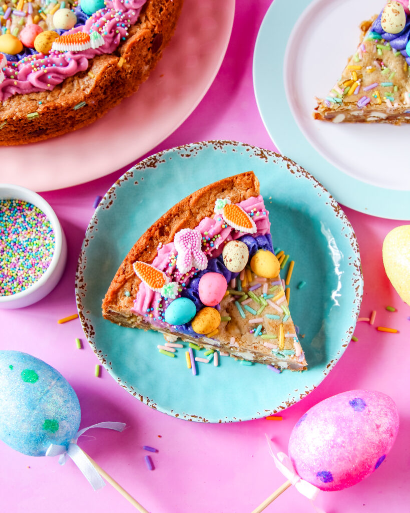 Egg-stravaganza Cookie Cake decorated with pastel swirls, nonpareils, and extra chocolate eggs on top.