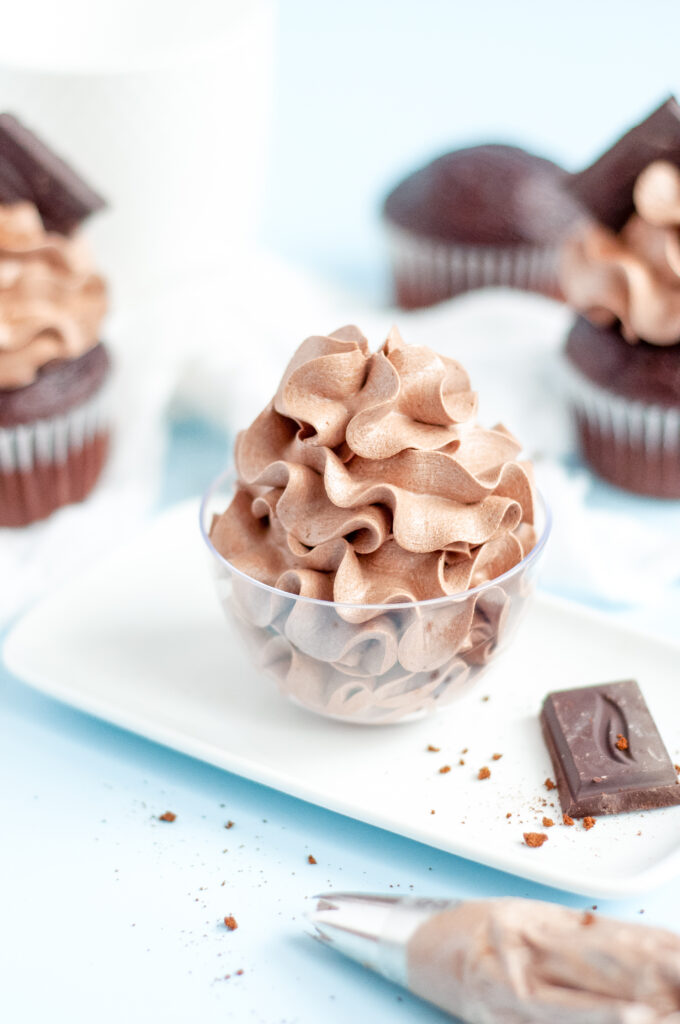 Close-up of chocolate espresso buttercream frosting swirled on a cupcake with a glossy, smooth finish.