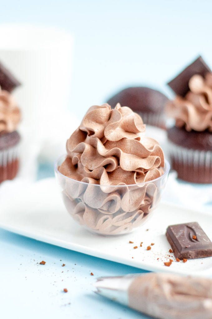 Close-up of chocolate espresso buttercream frosting swirled on a cupcake with a glossy, smooth finish.
