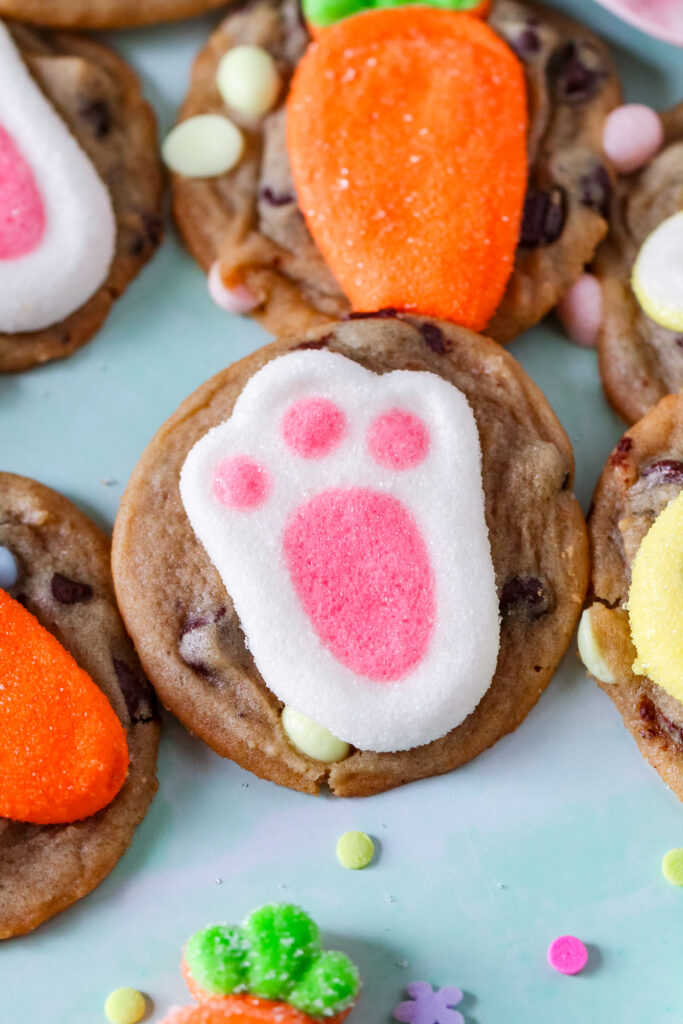 A fresh-baked chocolate chip cookie with a pastel marshmallow bunny pressed into the center.
