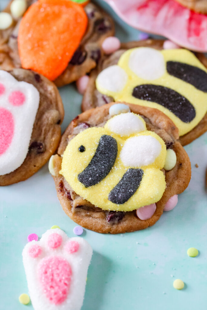 A fresh-baked chocolate chip cookie with a pastel marshmallow bunny pressed into the center.