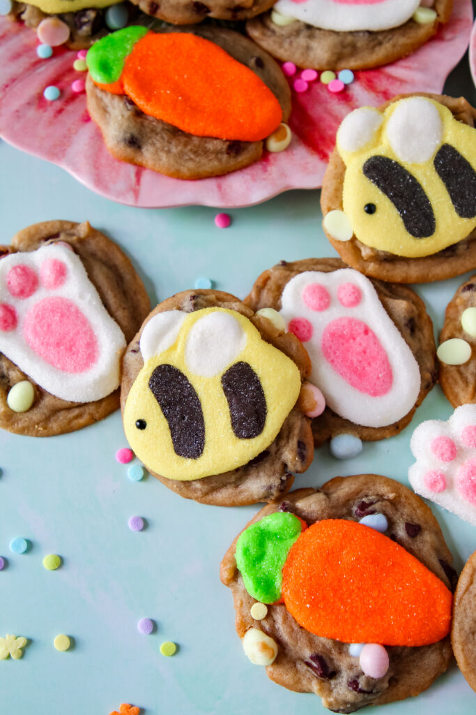 A fresh-baked chocolate chip cookie with a pastel marshmallow bunny pressed into the center.