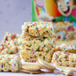 Colorful Lucky Charms cereal bars topped with rainbow sprinkles, Golden Oreo pieces, and melted white chocolate