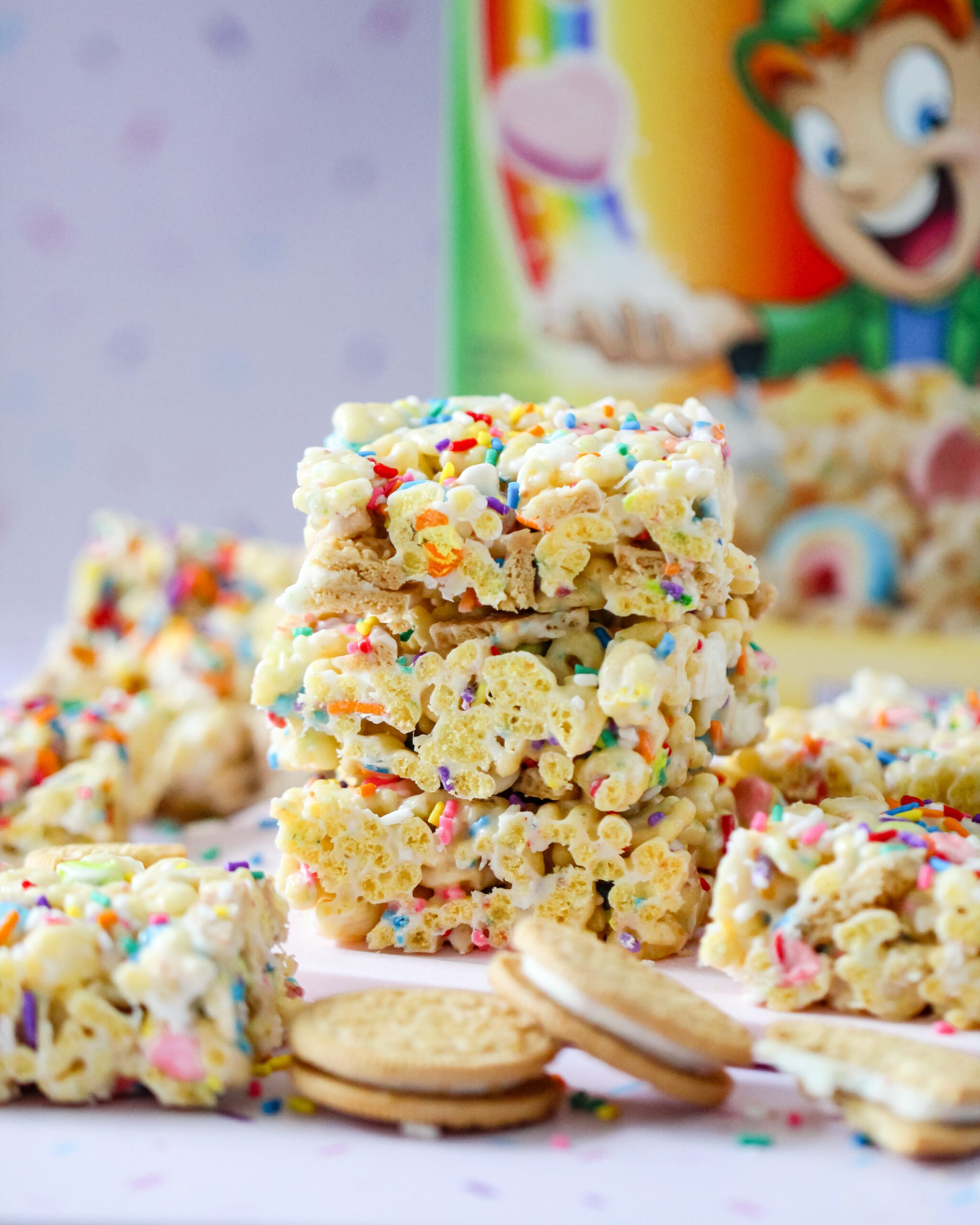 Colorful Lucky Charms cereal bars topped with rainbow sprinkles, Golden Oreo pieces, and melted white chocolate