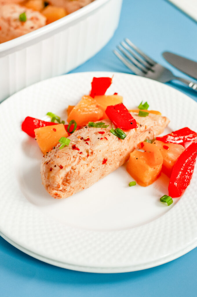 Colorful Hawaiian chicken cooked in a sticky pineapple-chili sauce with bell peppers and pineapple chunks served over white rice.