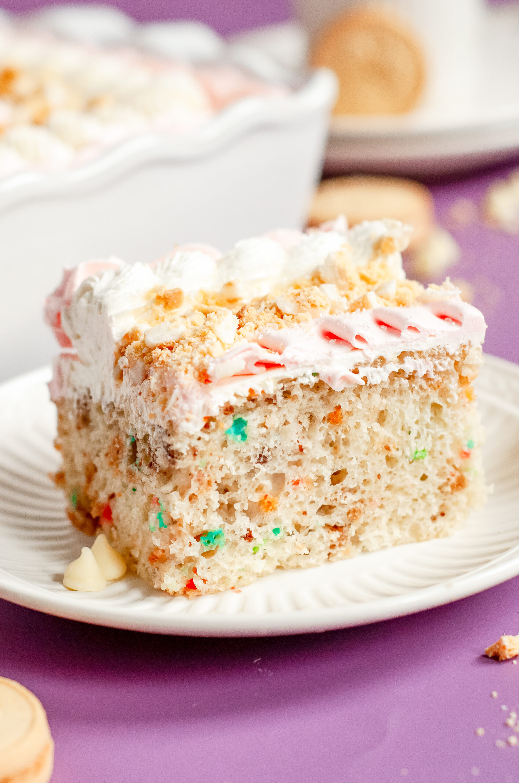 A pink and white frosted sheet cake with crushed golden Oreos, piped buttercream, and soft pastel sprinkles, perfect for Mother’s Day.