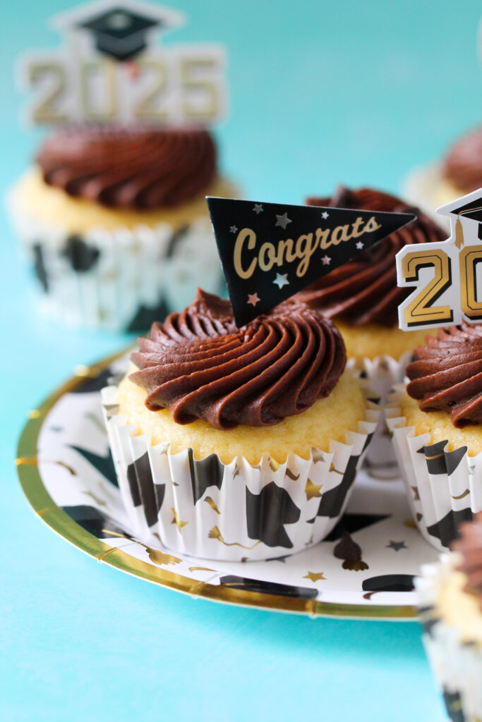 Chocolate almond cupcakes topped with swirled Nutella frosting and mini chocolate chips, perfect for graduation celebrations.