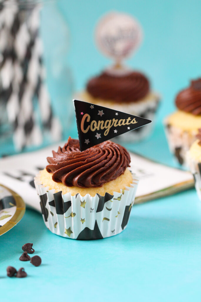 Chocolate almond cupcakes topped with swirled Nutella frosting and mini chocolate chips, perfect for graduation celebrations.