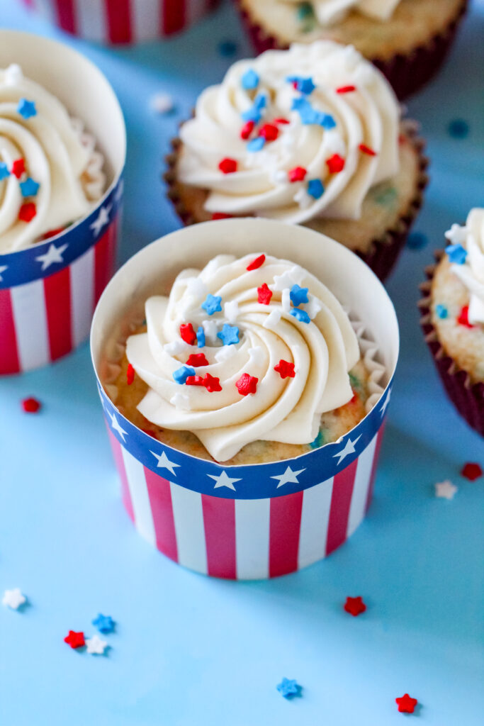 Patriotic Cupcake perfect for Fourth of July with patriotic sprinkles on top of the frosting in a festive patriotic cupcake liner.
