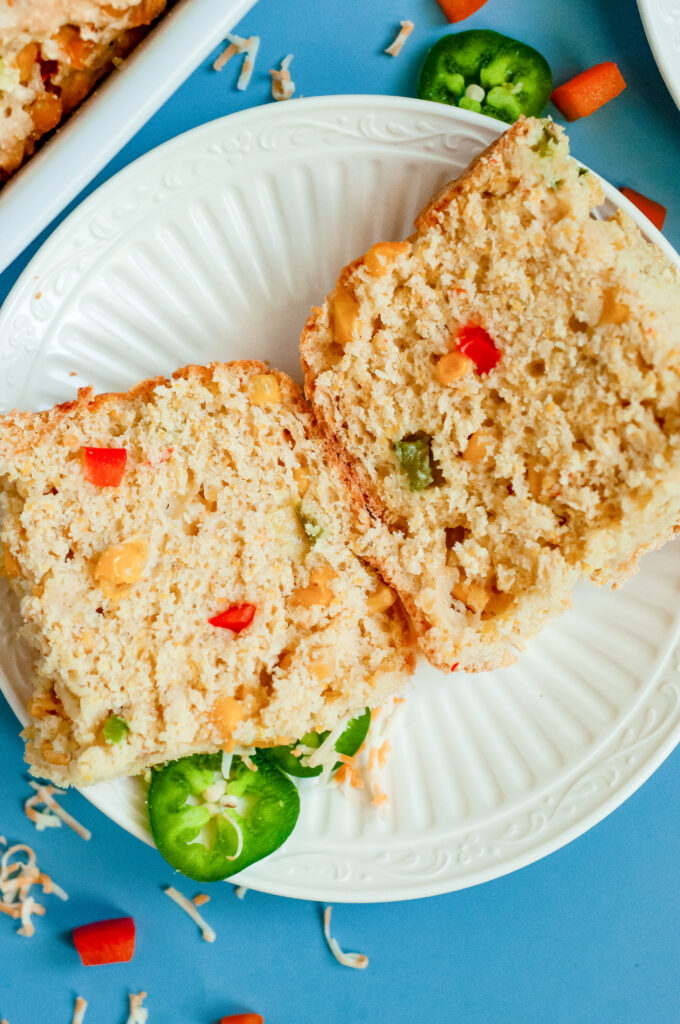 A slice of loaded cornbread with cheese, cornbread, and green onions using Dolly Parton's Cornbread Mix.