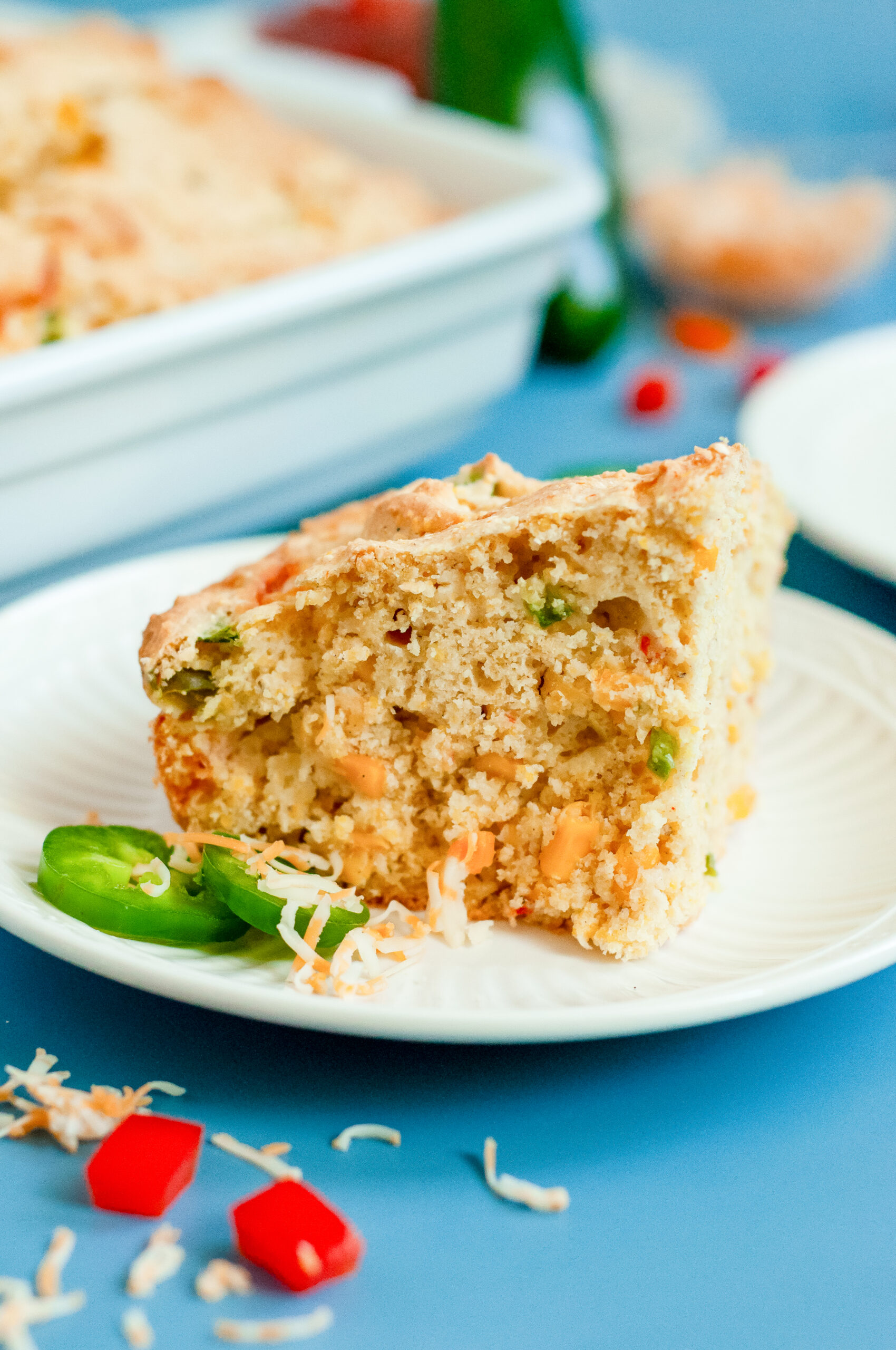 A slice of loaded cornbread with cheese, cornbread, and green onions using Dolly Parton's Cornbread Mix.