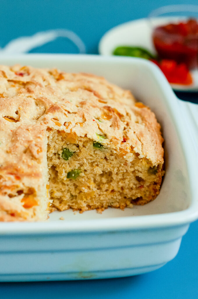 A loaf of loaded cornbread with cheese, cornbread, and green onions using Dolly Parton's Cornbread Mix.