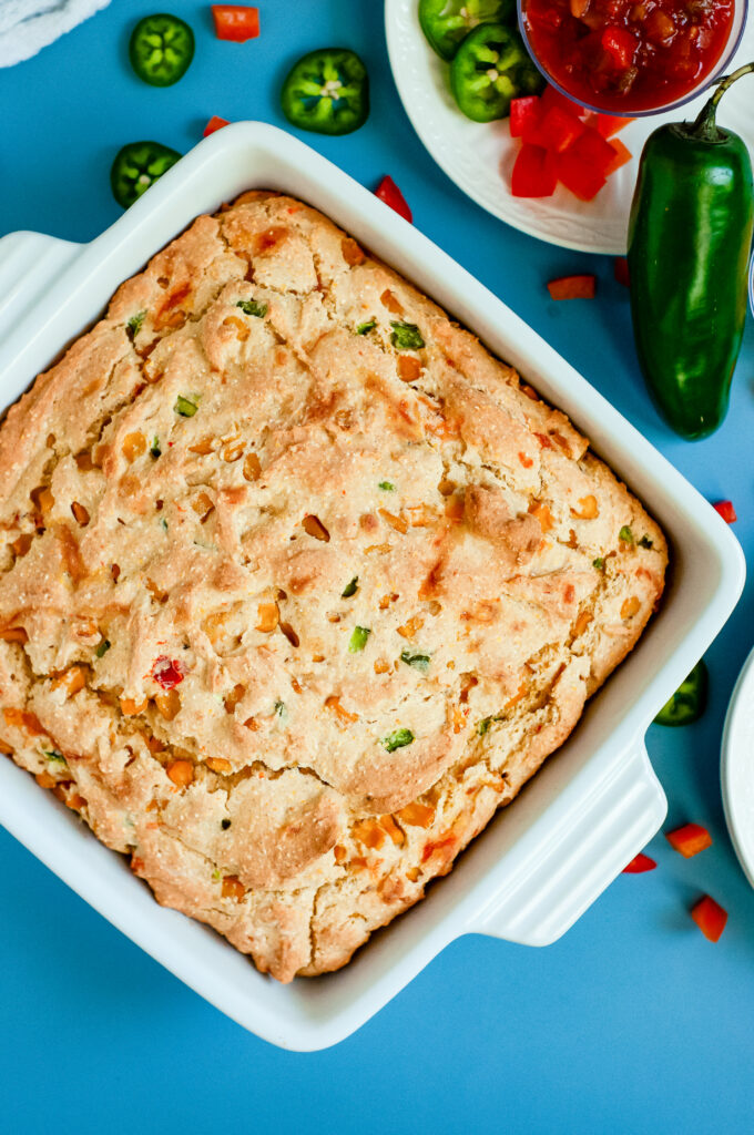 A loaf of loaded cornbread with cheese, cornbread, and green onions using Dolly Parton's Cornbread Mix.