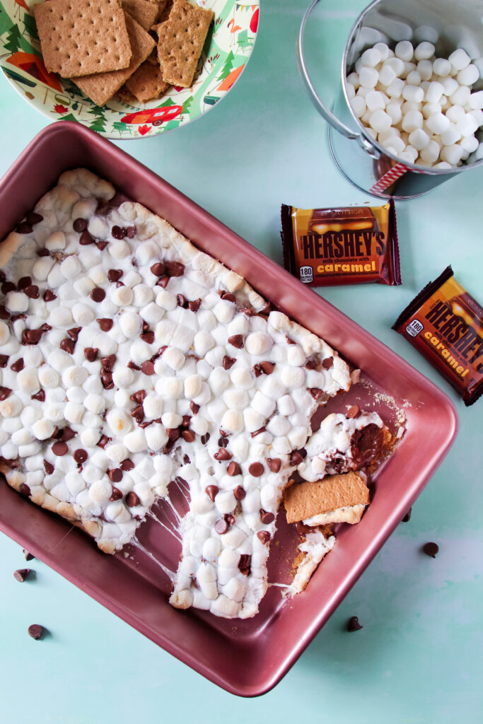 A pan of oven baked Caramel S'mores squares with marshmallows and chocolate.