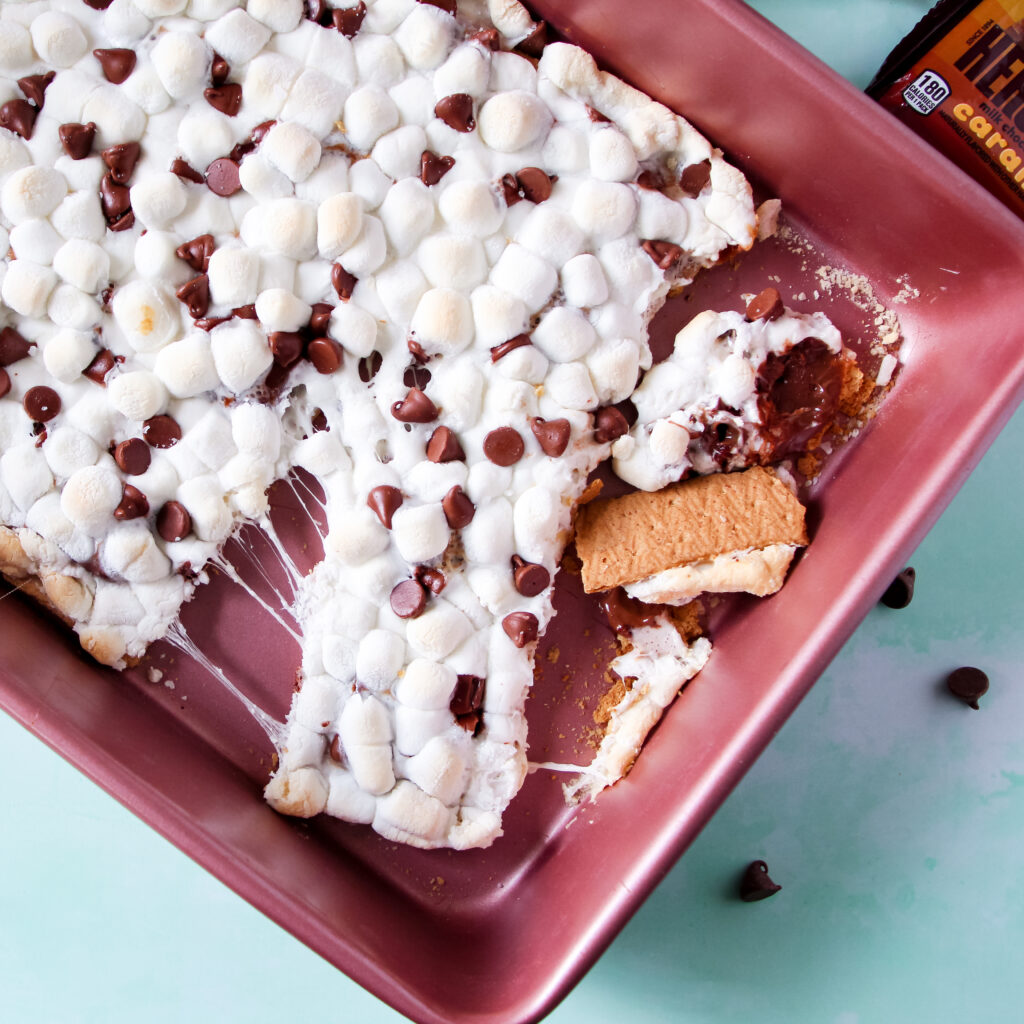 A dish of oven baked Caramel S'mores squares with marshmallows and chocolate.