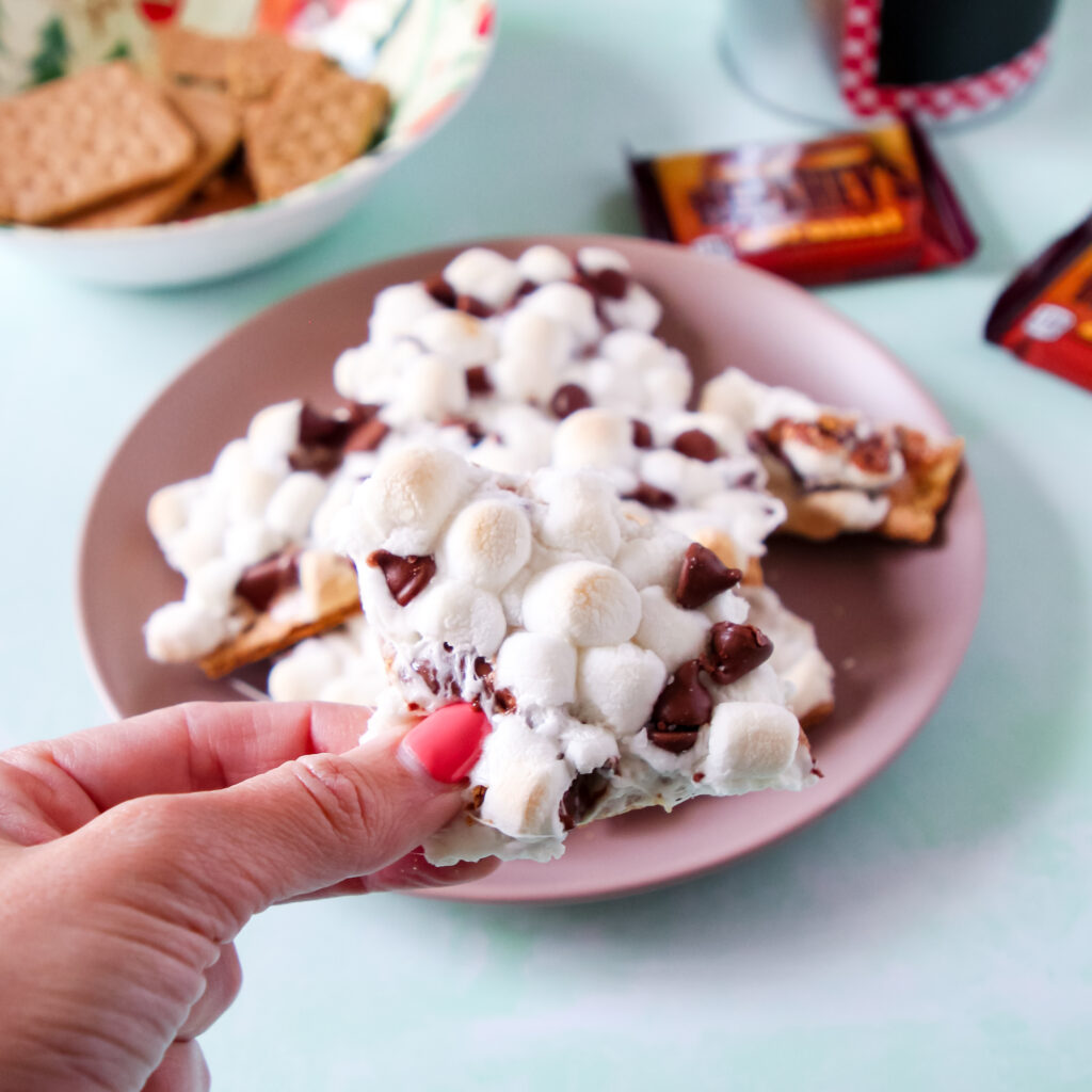 A plate of oven baked Caramel S'mores squares with marshmallows and chocolate.