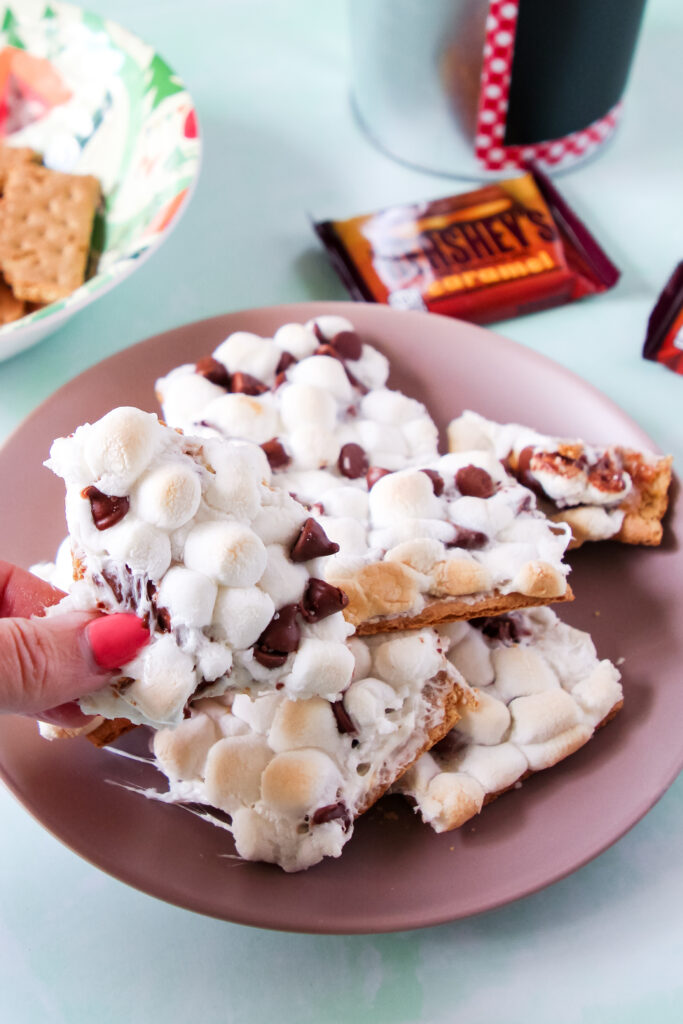 A plate of oven baked Caramel S'mores squares with marshmallows and chocolate.