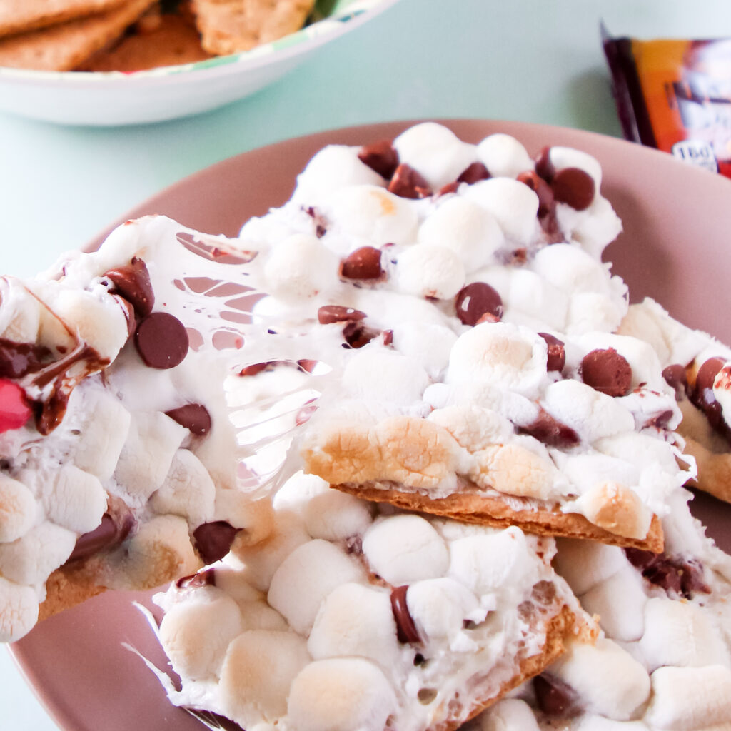 A plate of oven baked Caramel S'mores squares with marshmallows and chocolate.