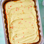 Pineapple Party Sheet Cake in a pan topped with sprinkles.