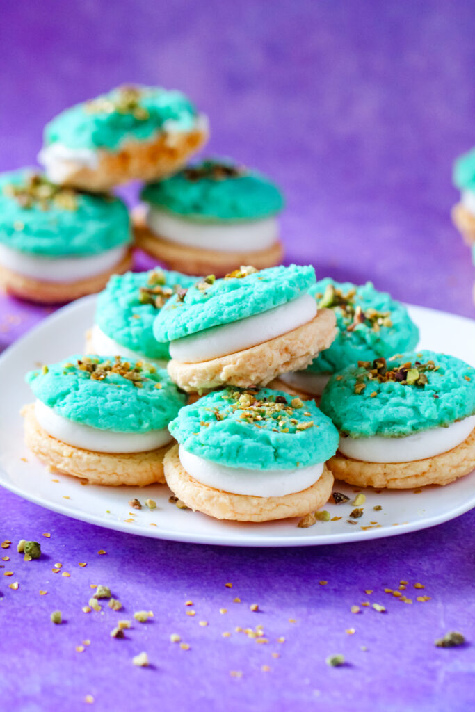 A plate of Pistachio and Orange Blossom Cookie Sandwiches Inspired by Jasmine from Aladdin.