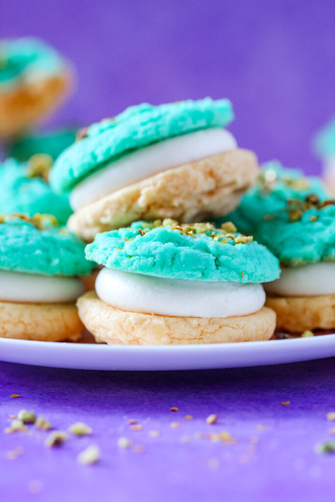 A plate of Pistachio and Orange Blossom Cookie Sandwiches Inspired by Jasmine from Aladdin.