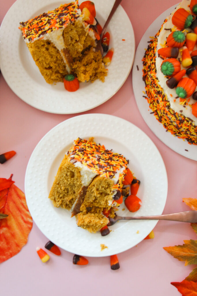Pumpkin Party Sprinkle Cake covered in orange, yellow, and brown sprinkles and topped with candy corn and candy pumpkins.