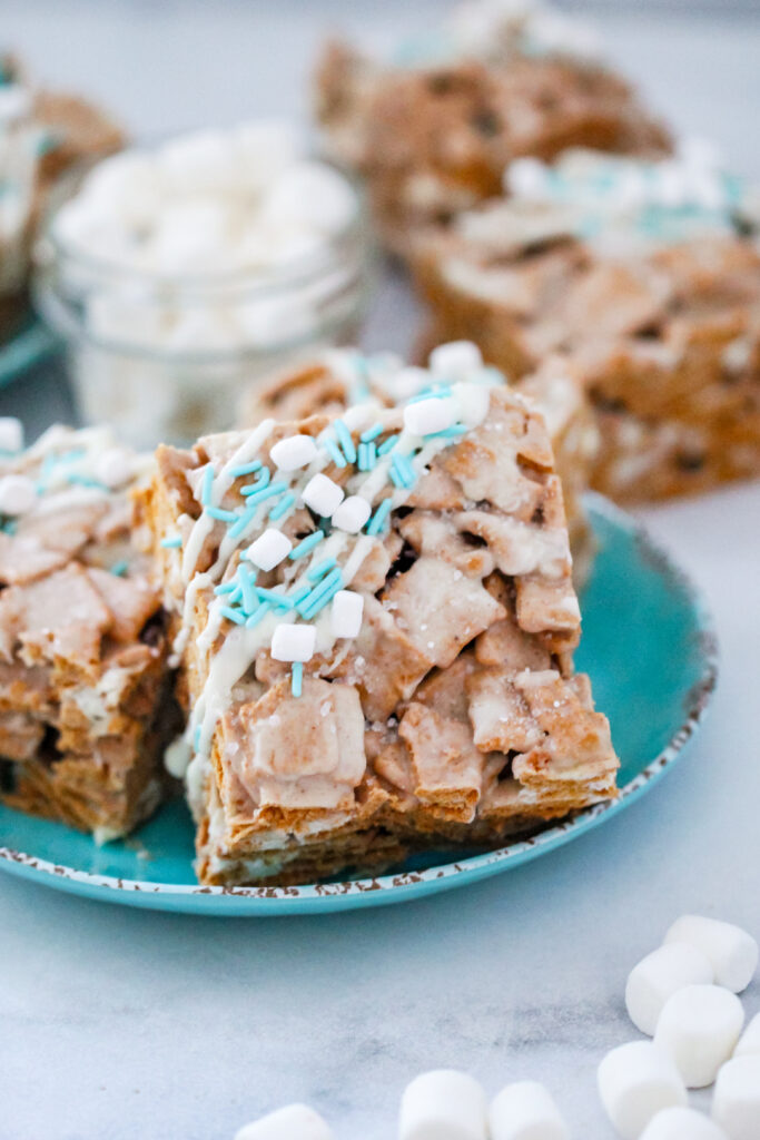 An image of Snow Days Golden Grahams Bars — chewy marshmallow cereal treats made with Golden Grahams, white chocolate, and festive winter sprinkles.
