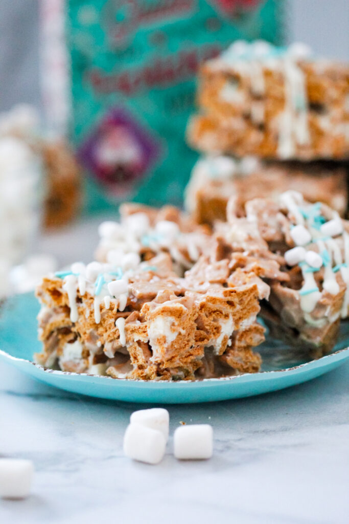 An image of Snow Days Golden Grahams Bars — chewy marshmallow cereal treats made with Golden Grahams, white chocolate, and festive winter sprinkles.